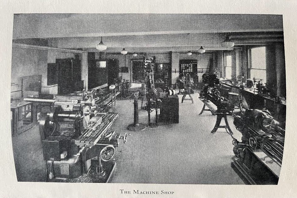 Pupin 1111 in 1927, when Pupin itself was constructed. The image is in black and white, with old mills, lathes, and other manufacturing equipment. The image is labeled 'The Machine Shop'